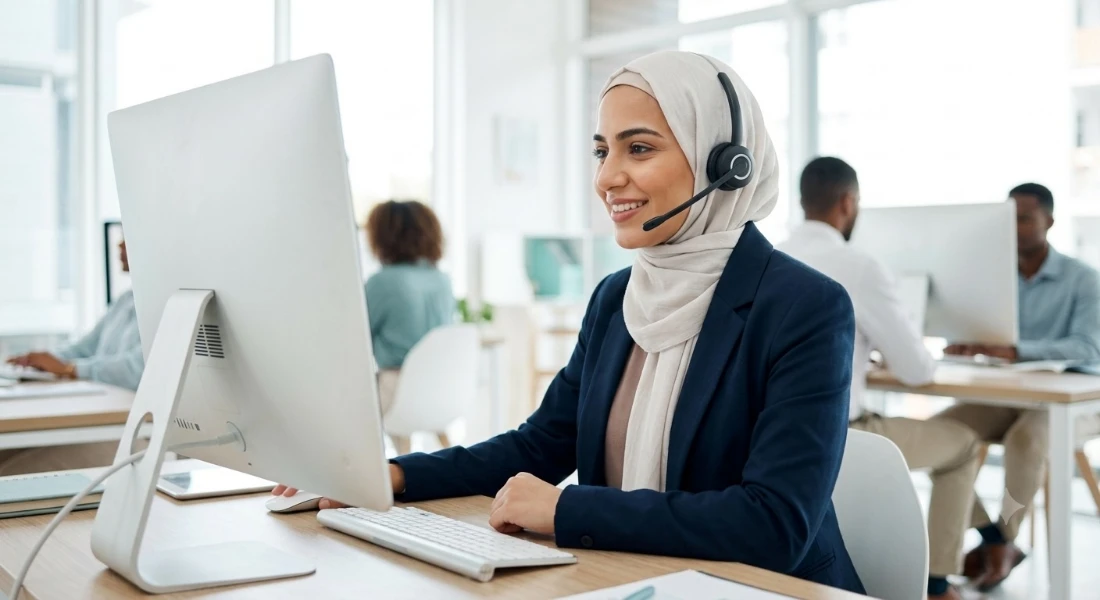 A contact centre agent handling a customer conversation at a single desktop workspace.